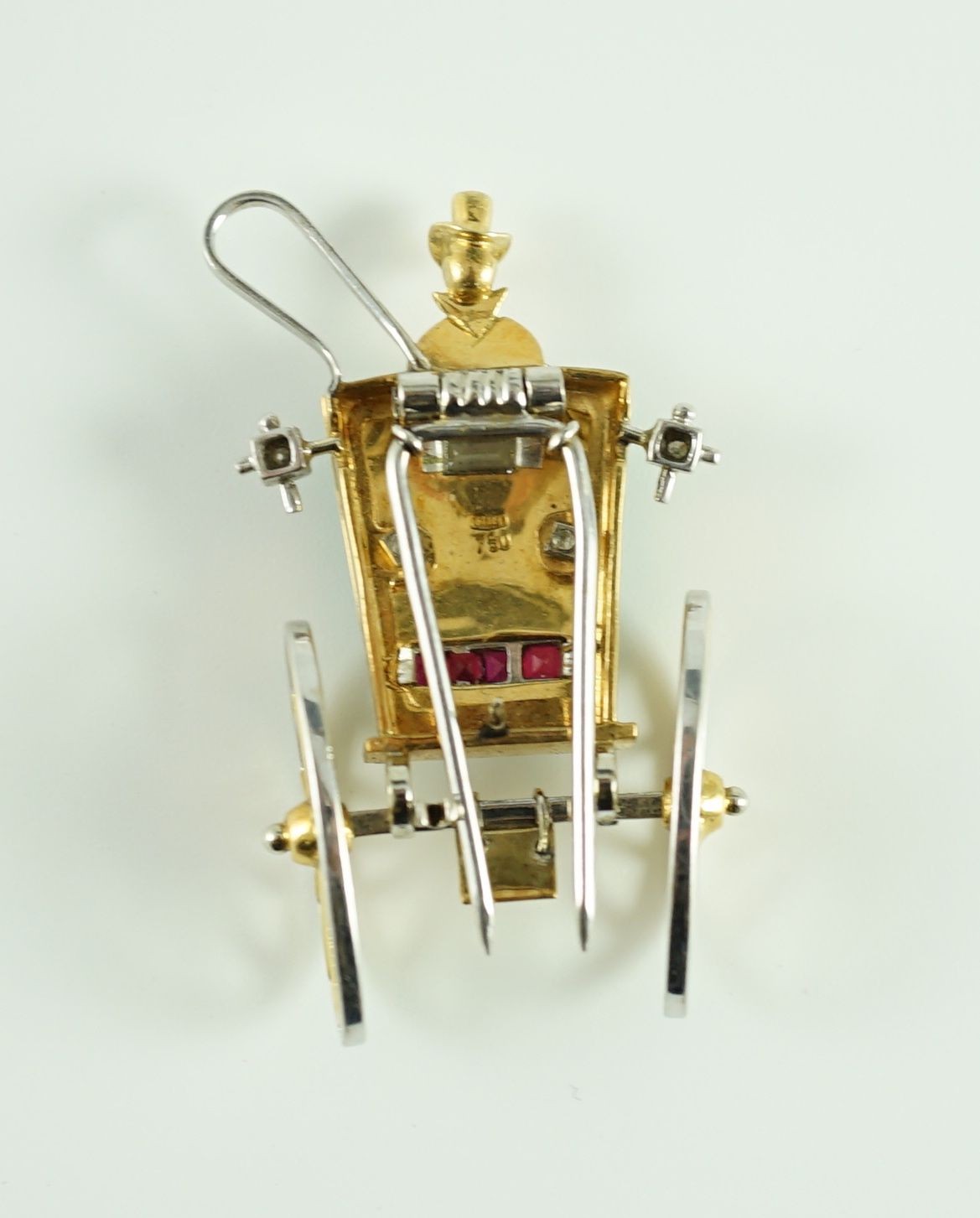 A mid 20th century Italian two colour 18ct gold, green enamel, ruby and diamond set novelty clip brooch, modelled as the rear view of a carriage with driver